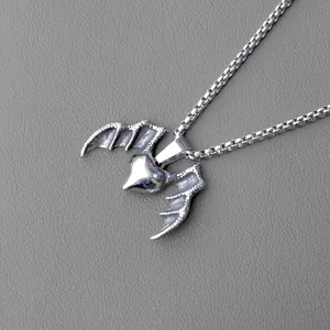 Retro gothic necklace with silver heart and bat wing pendant on a dark background