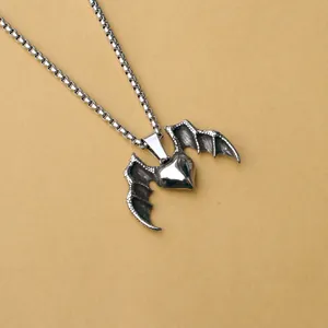 Macro shot of silver gothic bat wings heart pendant with detailed bone textures
