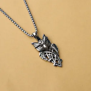 Macro détaillée du pendentif hibou avec des motifs de nœuds celtiques sur acier vintage