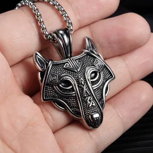 Nordic Celtic wolf head pendant necklace in vintage silver finish held in hand