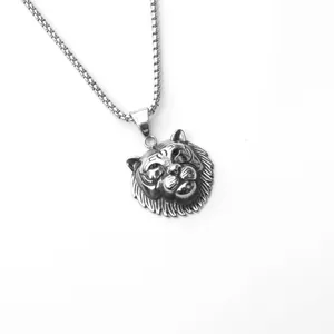Gros plan du pendentif tête de tigre argenté avec chaîne box et détails ciselés