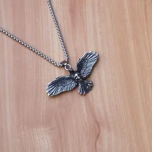 Detail of vintage eagle wings pendant with skull motif and steel pearl chain