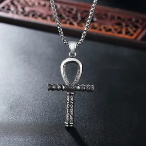 Macro detail van vintage zilveren Ankh kruis hanger met Oog van Horus reliëf op parelketting