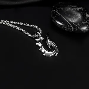 Mens stainless steel hook pendant necklace on a sleek black stone and silk background