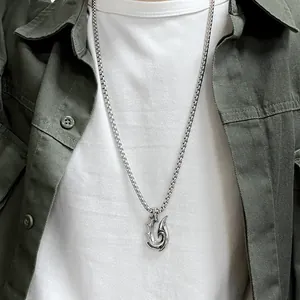 Close-up of gothic stainless steel hook pendant on a square link chain for men