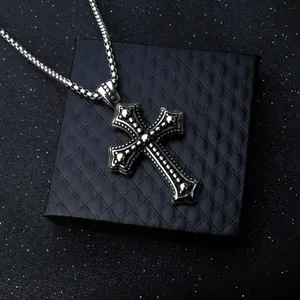 Collier croix gothique vintage avec chaîne gourmette sur une boîte cadeau noire de luxe
