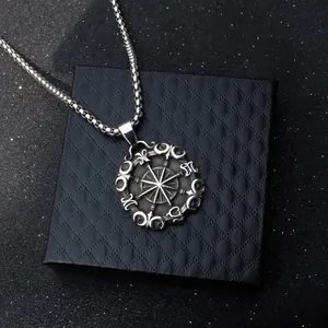 Collana da uomo con ciondolo a bussola vintage in acciaio su una scatola di gioielli