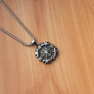 Collana vintage in acciaio con ciondolo bussola e fasi lunari su legno