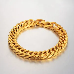 Close-up of golden wide Cuban link bracelet with fold-over clasp and metallic finish