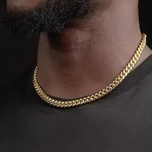 Gros plan d'un collier à maillons cubains dorés polis pour hommes sur fond noir
