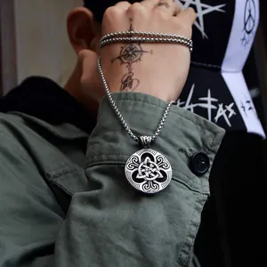 Primer plano de un colgante de nudo céltico plateado en cadena box para estilo punk