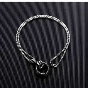 Detail of silver titanium steel necklace with punk skull hand claw pendant and ring