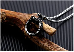 Macro shot of retro stainless steel eagle head ring pendant on dark wood branch