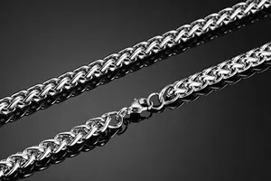 Gros plan d'un collier chaîne de blé argentée avec un fermoir mousqueton et éclat métallique