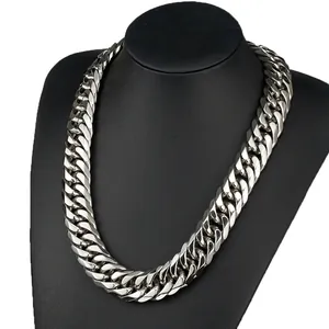 Macro detail of heavy silver cuban link chain with high-polish finish on a black bust