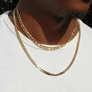 Détail de colliers superposés Figaro et gourmette en or sur un mannequin en t-shirt blanc