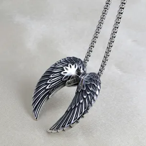 Close-up of vintage stainless steel angel wing pendant with detailed feather texture
