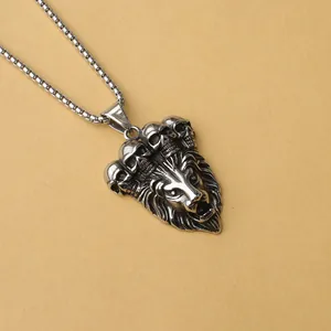 Detalle del colgante de cabeza de león y calaveras en acero inoxidable pulido estilo punk