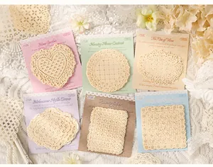 Detailed view of cream lace paper doilies with intricate hollow-out floral patterns