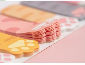 Macrodetail van kattenpoot plaknotities met dikke gelaagde papierstructuur en pastelkleuren