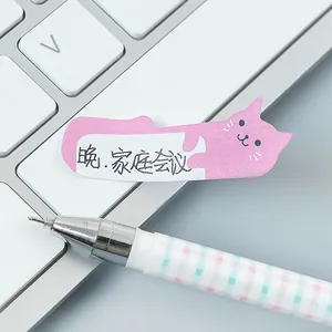 Dettaglio di post-it a forma di gatto rosa con nota scritta a mano sulla tastiera