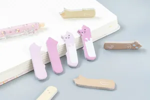 Dettaglio di simpatici post-it a forma di gatto su un taccuino con penna floreale