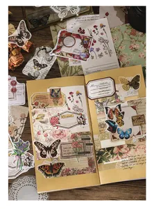Dettagli di adesivi vintage in PET con motivi di farfalle e fiori su un'agenda