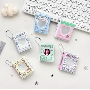 Detalle de mini álbumes de fotos con ventanas de corazón y colgantes de cadena de bolas
