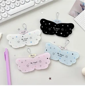 Gros plan de porte-cartes en acrylique ailes d'ange avec de jolis motifs d'étoiles