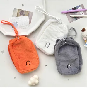Detail of plush fox storage bags in orange, white, and grey with lanyard and zipper