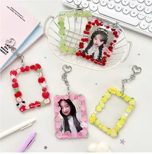 Detailed view of acrylic fruit photo holders with heart keychains on a desk