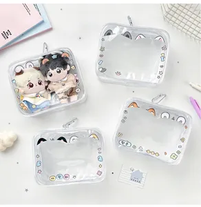 Close-up of clear PVC doll display cases with cute animal ears and metal carabiners