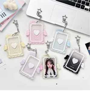 Close-up of heart-shaped acrylic photocard holders with angel wings and star keychains