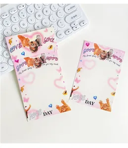 Detalle de blocs de notas de gatos con patrones de corazones rosas y empaque con colgador