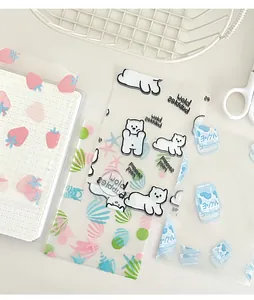 Macro detail of cute PET stickers with bears and strawberries on a grid journal