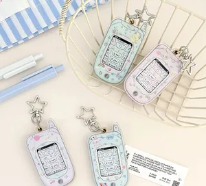 Detail of four acrylic Y2K phone-shaped keychains with cute cartoon motifs and star hooks
