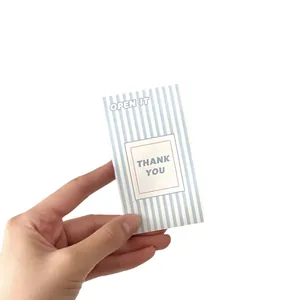 Blue and white striped mini thank you envelope held by hand for gift packaging stickers