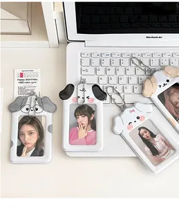 Detail of four cute dog-shaped PVC card holders with bead chains on a white laptop