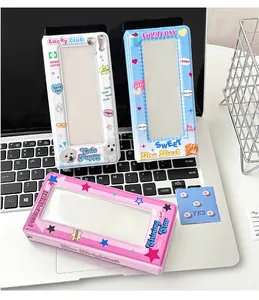 Three Y2K cartoon photocard holders with transparent windows on a laptop keyboard
