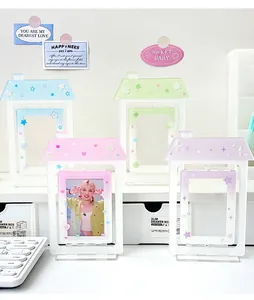 Detail of four acrylic house-shaped photo frames with star and heart themes on a desk