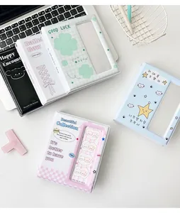 Flat lay of colorful photocard albums in pastel colors on a desk with laptop keyboard