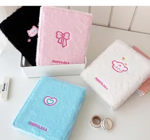 Detalle de la carpeta de peluche con motivos bordados de gato y corazón en cuatro colores