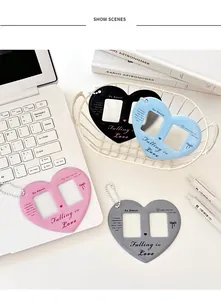 Flat lay of heart-shaped photocard holders in four colors with bead chains and pens