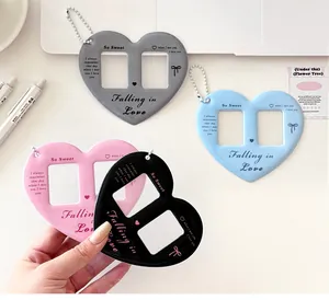 Macro detail of heart-shaped acrylic dual photo frame keychain with silver metal chain