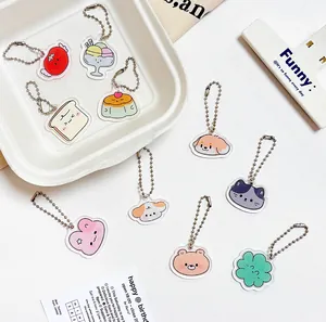 Mise à plat de jolis porte-clés en acrylique avec divers motifs de desserts et d'animaux