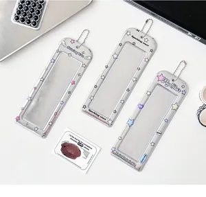 Trois porte-cartes argentés avec motifs d'étoiles et chaînes sur un bureau blanc