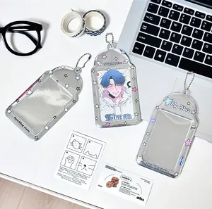Close-up of silver star photocard holders with bead chains on a minimalist desk