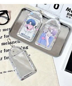 Detail view of silver star acrylic photocard holders with chains on a stylist desk