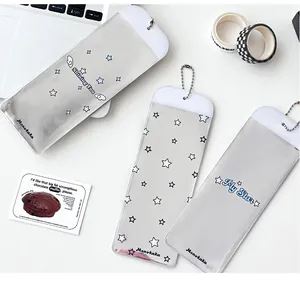 Détail du porte-carte en PVC argenté brillant avec étoiles et chaînette perles