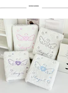 Vista detallada de cuatro archivadores A6 de felpa bordados con alas de ángel y corazones